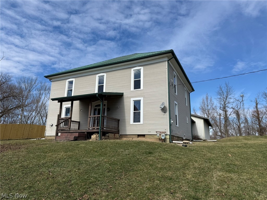 Back of property with a lawn