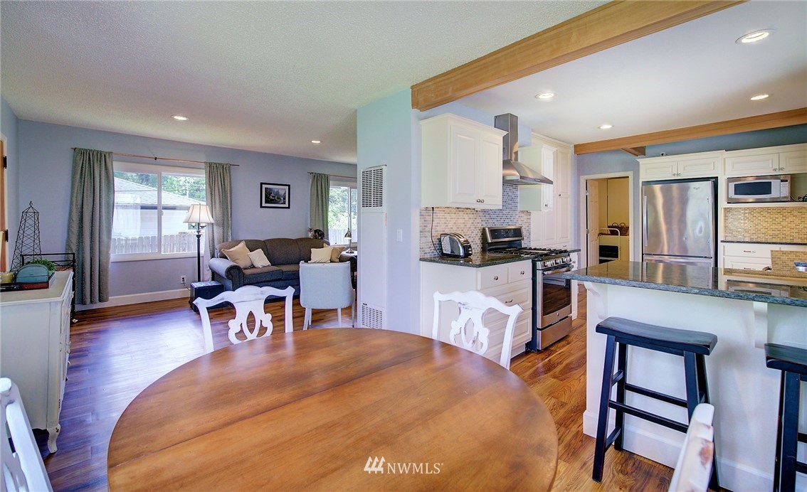 24316 Meridian Avenue South Bothell, WA 98021 - Photo 12 of 29 a living room with stainless steel appliances kitchen island granite countertop furniture and a wooden floor