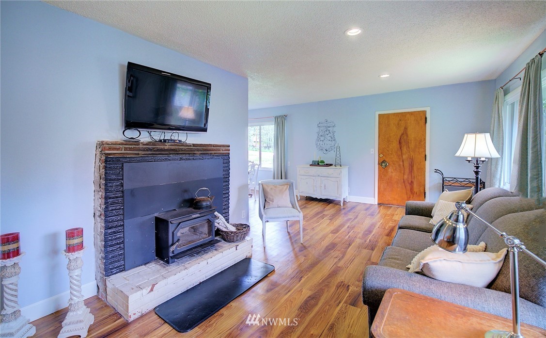 24316 Meridian Avenue South Bothell, WA 98021 - Photo 17 of 29 a living room with furniture a flat screen tv and a fireplace