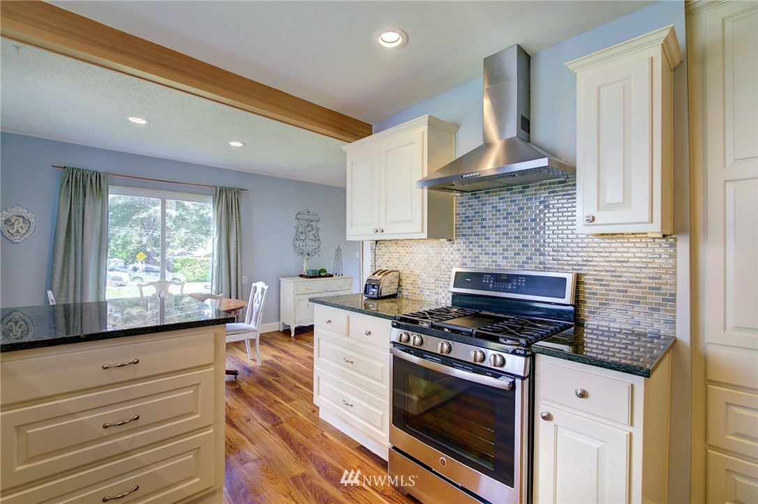 24316 Meridian Avenue South Bothell, WA 98021 - Photo 7 of 29 a kitchen with granite countertop a stove and a sink