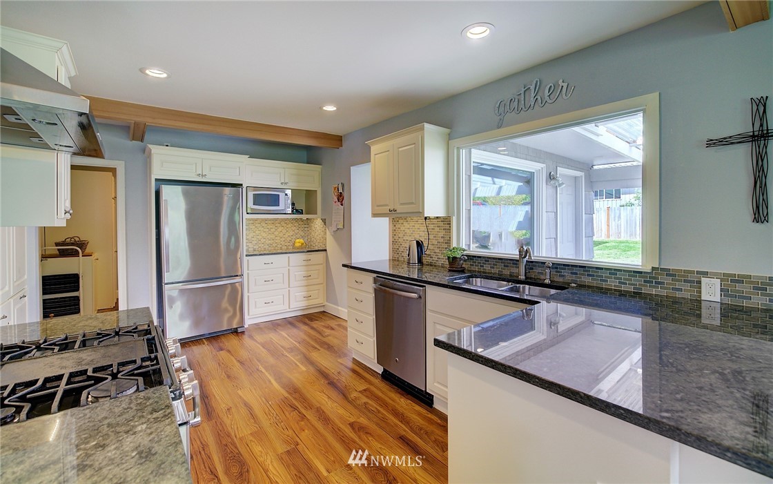 24316 Meridian Avenue South Bothell, WA 98021 - Photo 9 of 29 a kitchen with granite countertop a refrigerator and a sink