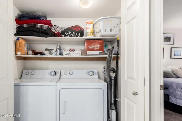 a view of washer and dryer with racks on the wall