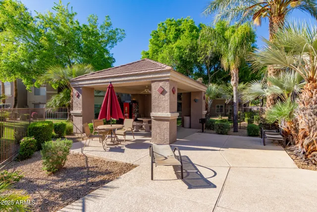 a view of patio with a table and chairs under an umbrella