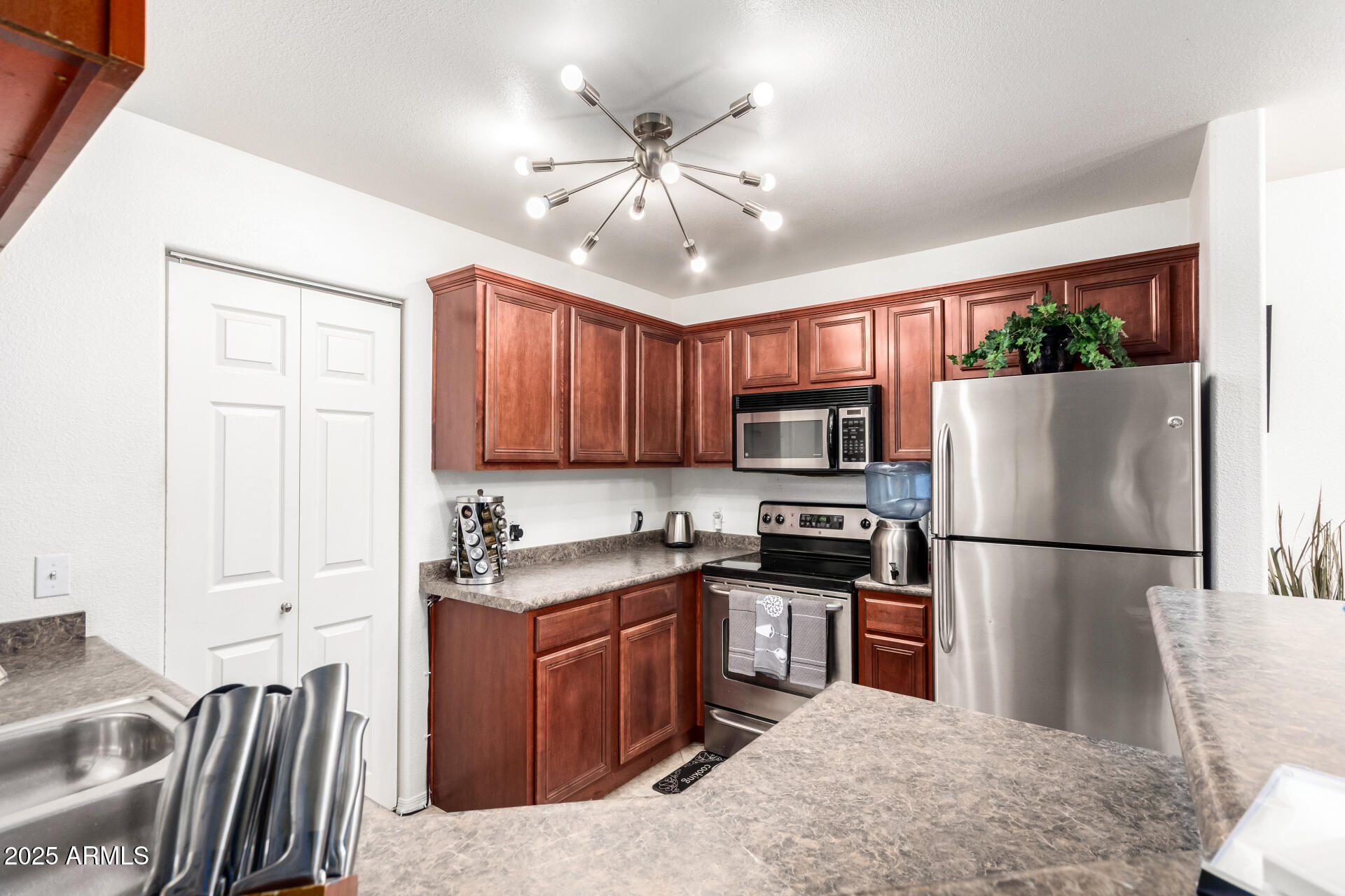 17017 North 12th Street, Unit 1123 Phoenix, AZ 85022 - Photo 3 of 48 a kitchen with stainless steel appliances granite countertop a stove top oven a refrigerator a sink a dining table and chairs with wooden floor