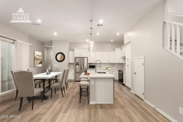 a kitchen with stainless steel appliances granite countertop white cabinets and a stove top oven