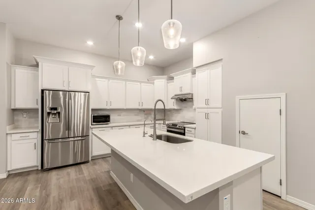 an empty room with windows and chandelier fan