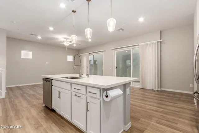an empty room with chandelier fan and windows