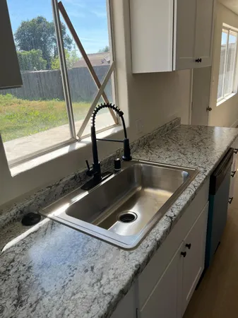 a kitchen with granite countertop a sink and a window