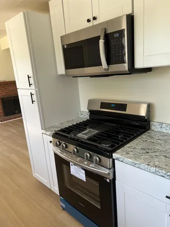 a stove top oven sitting inside of a kitchen