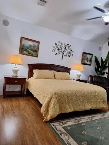 a bedroom with a large bed and a chandelier