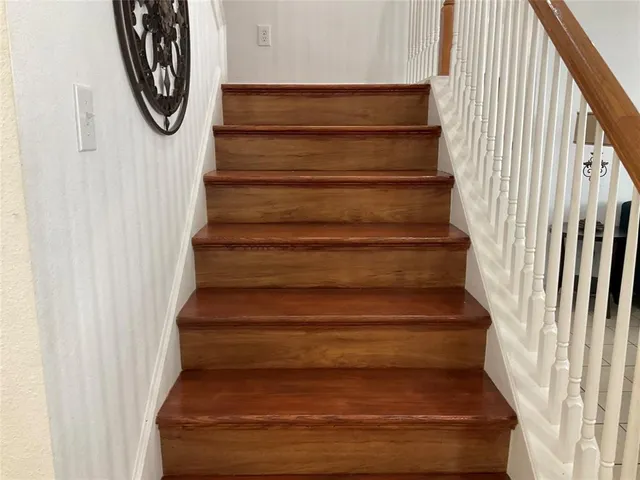 a view of staircase with lots of frames on wall and windows