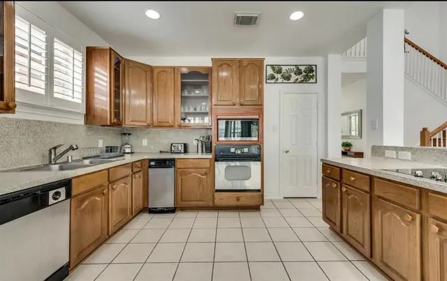 a kitchen with stainless steel appliances granite countertop a sink counter space cabinets and a large window