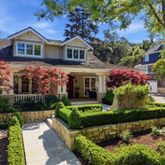 a front view of a house with a yard and potted plants