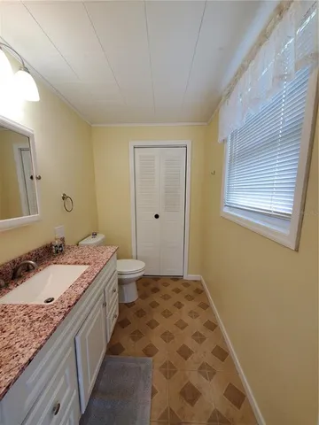a bathroom with a granite countertop sink a toilet and mirror