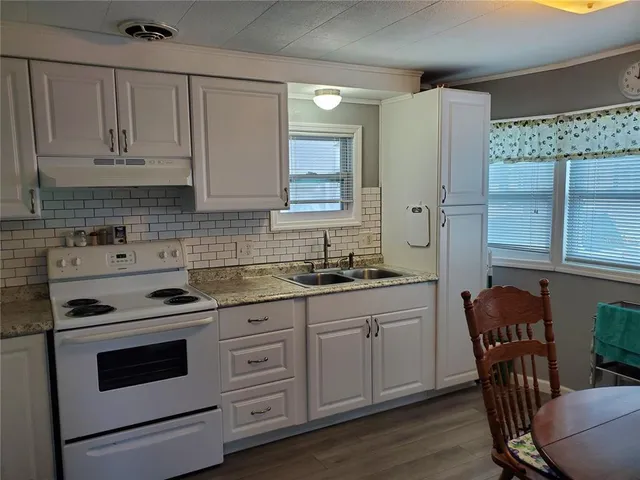 a kitchen with stainless steel appliances granite countertop a stove a sink cabinets and a refrigerator