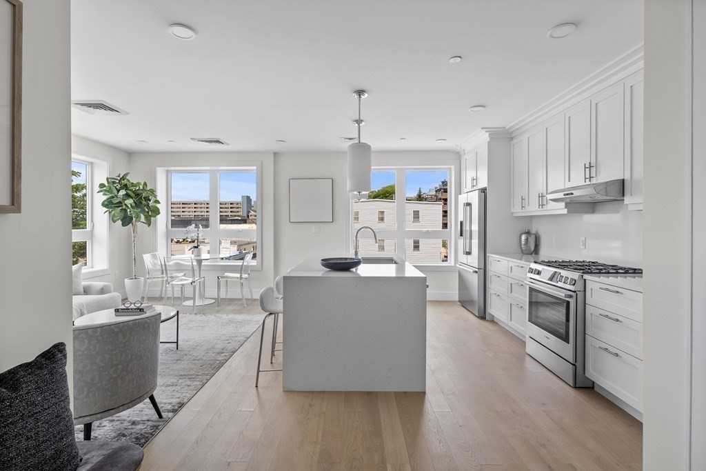 301 Border Street, Unit 406 Boston, MA 02128 - Photo 9 of 38 a large white kitchen with stainless steel appliances