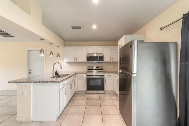 a kitchen with stainless steel appliances granite countertop a refrigerator and a sink