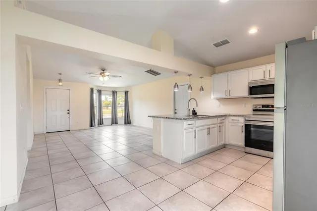 a kitchen with stainless steel appliances granite countertop a refrigerator and a stove top oven