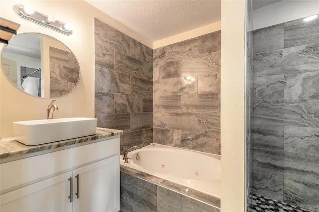 a bathroom with a tub sink and mirror