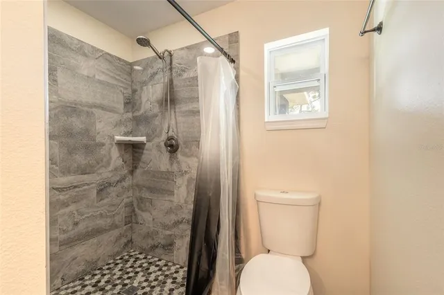 a bathroom with a toilet and a shower
