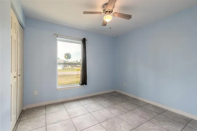 an empty room with windows and fan