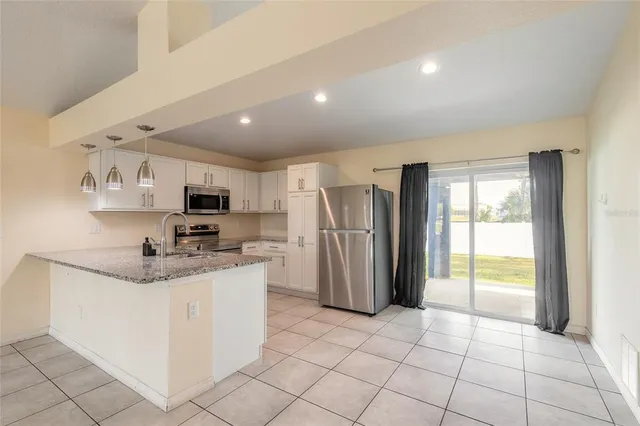 a kitchen with stainless steel appliances granite countertop a refrigerator sink and cabinets