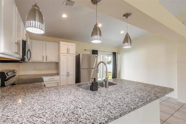 a view of a kitchen with a sink and refrigerator
