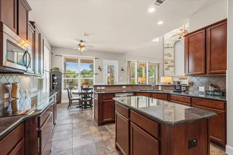 a kitchen with granite countertop a sink stove and cabinets