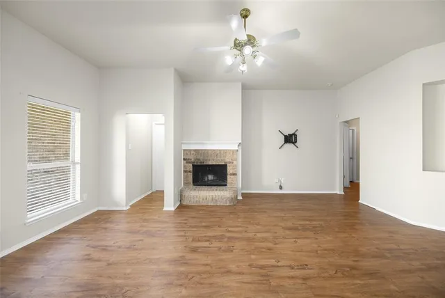 a view of an empty room with a fireplace and a window
