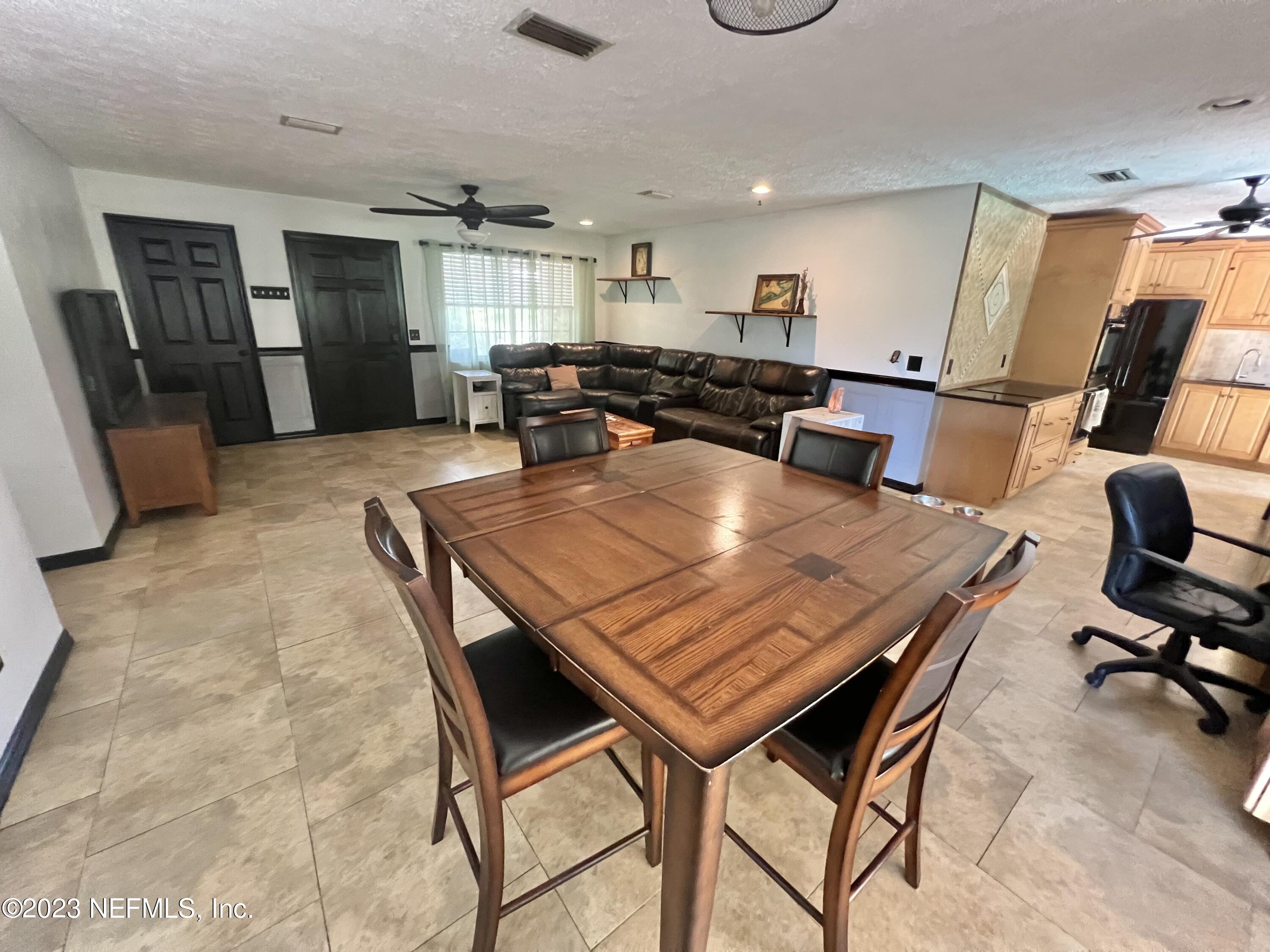 210 Prince Road St. Augustine, FL 32086 - Photo 8 of 43 a dining hall with stainless steel appliances granite countertop a stove a sink a dining table and chairs with wooden floor