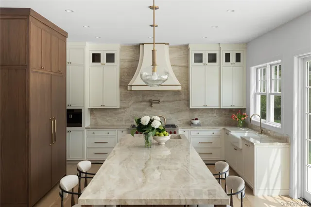 a kitchen with stainless steel appliances granite countertop a white cabinets and a chandelier