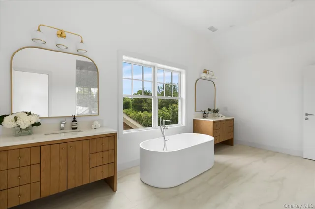 a bathroom with a tub a sink and mirror