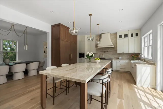 a kitchen with stainless steel appliances kitchen island granite countertop a table chairs and a refrigerator