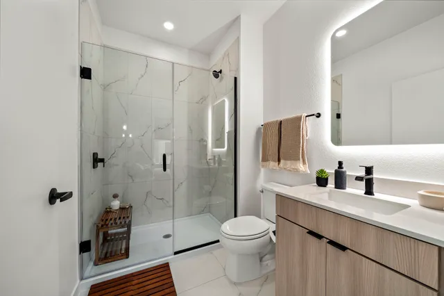 a bathroom with a sink a toilet and shower