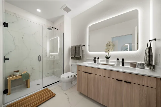 a bathroom with a double vanity sink toilet and shower
