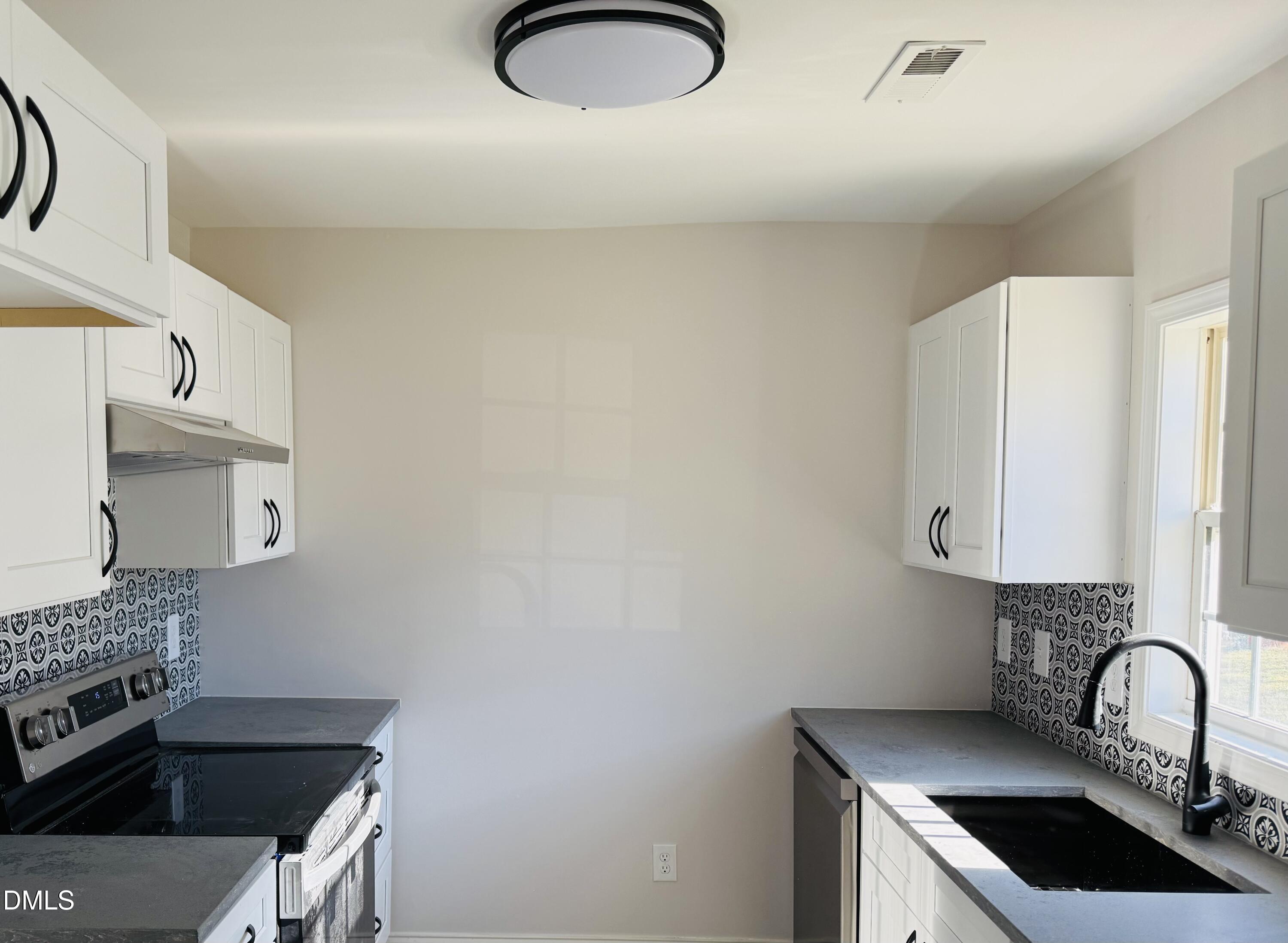 415 Sowell Street Durham, NC 27701 - Photo 6 of 17 a kitchen with granite countertop a sink a stove and cabinets