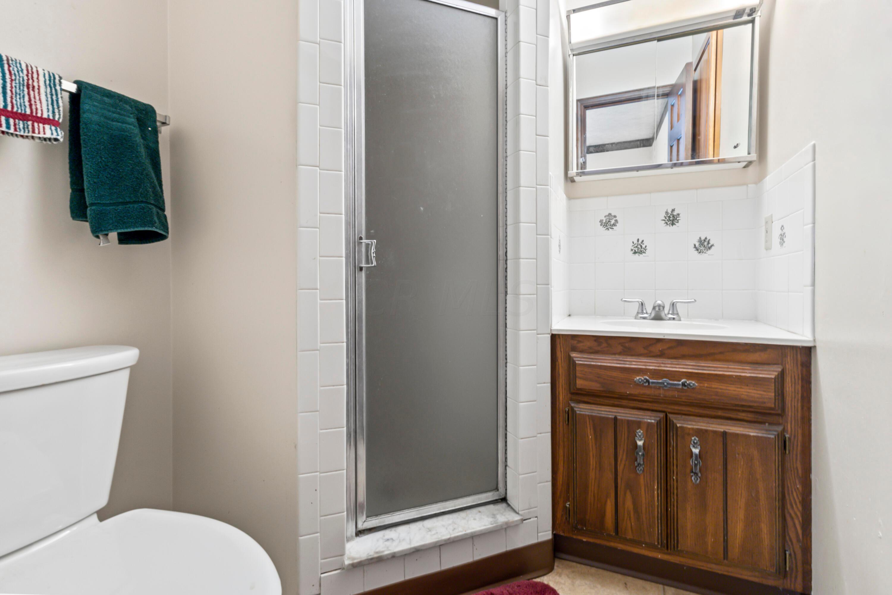 5764 Cheshire Road Galena, OH 43021 - Photo 15 of 59 • Neutral vinyl flooring
• Tan painted walls
• Shower stall with ceramic
tile surround
• Enclosed vanity with single
bowl, cultured marble sinktop
& ceramic tile surround
• Lighted & mirrored
medicine cabinet
• Ceiling exhaust