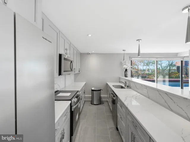 a kitchen with a refrigerator and white cabinets