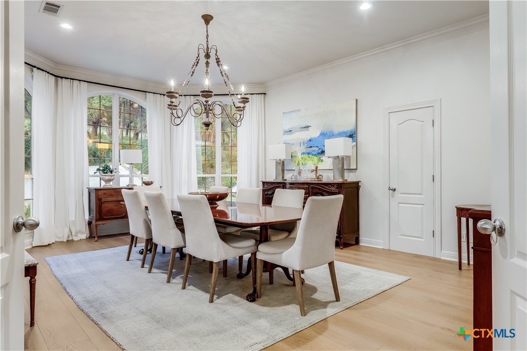 1307 Osprey Ridge Loop Lago Vista, TX 78645 - Photo 12 of 40 a dining room with furniture a chandelier and wooden floor