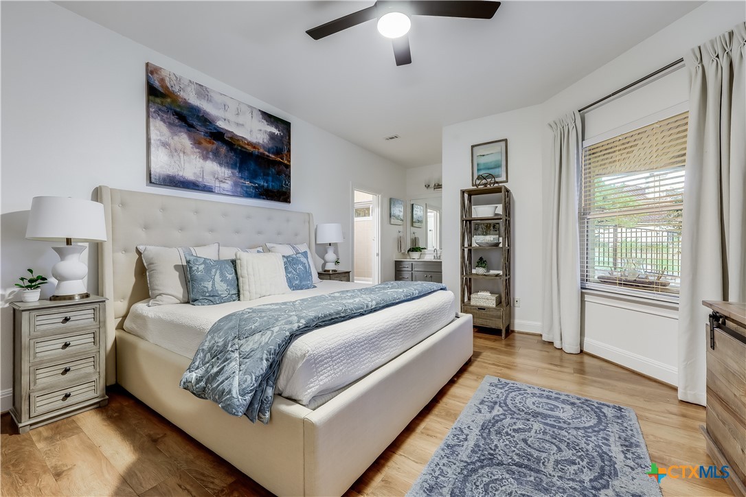 1307 Osprey Ridge Loop Lago Vista, TX 78645 - Photo 21 of 40 a spacious bedroom with a large bed and a chandelier
