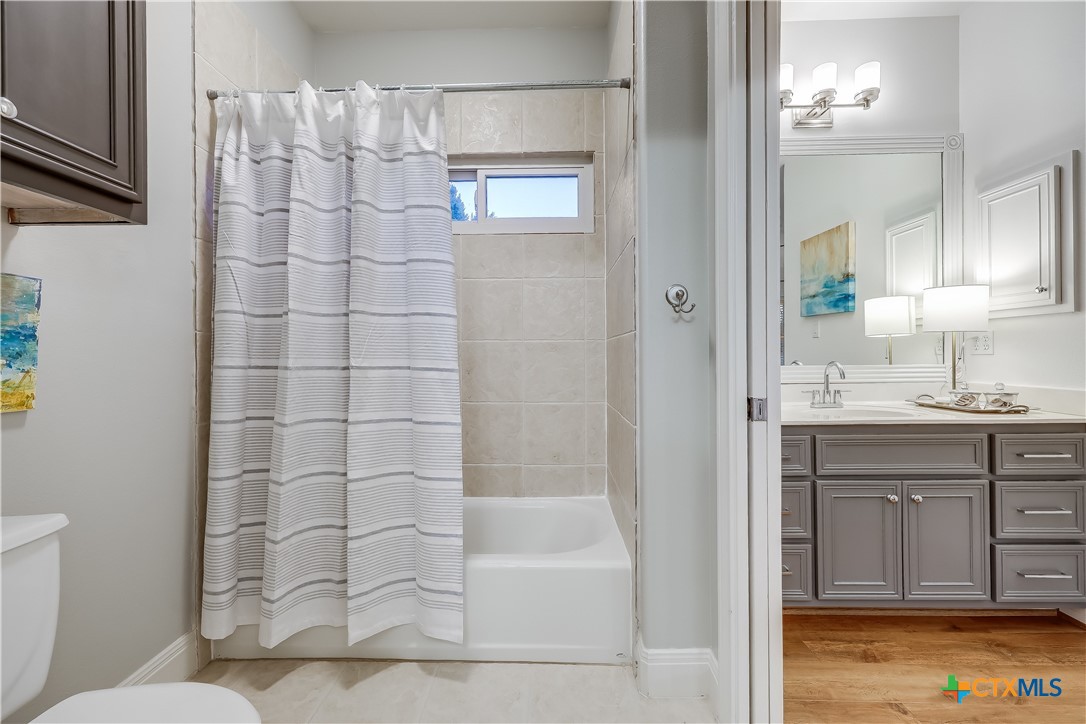 1307 Osprey Ridge Loop Lago Vista, TX 78645 - Photo 23 of 40 a bathroom with a granite countertop sink a toilet and shower