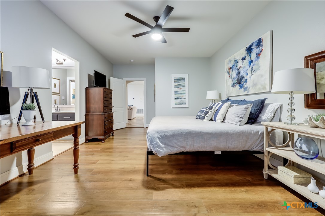 1307 Osprey Ridge Loop Lago Vista, TX 78645 - Photo 24 of 40 a bedroom with a bed and a chandelier