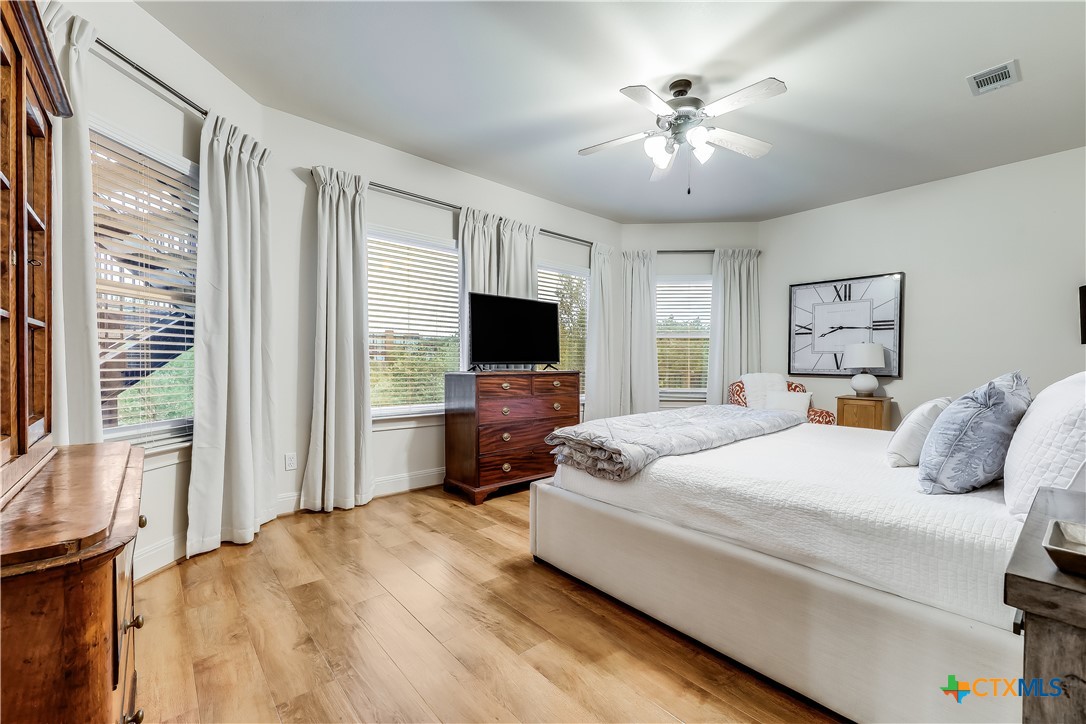 1307 Osprey Ridge Loop Lago Vista, TX 78645 - Photo 29 of 40 a bedroom with a large bed and a flat screen tv