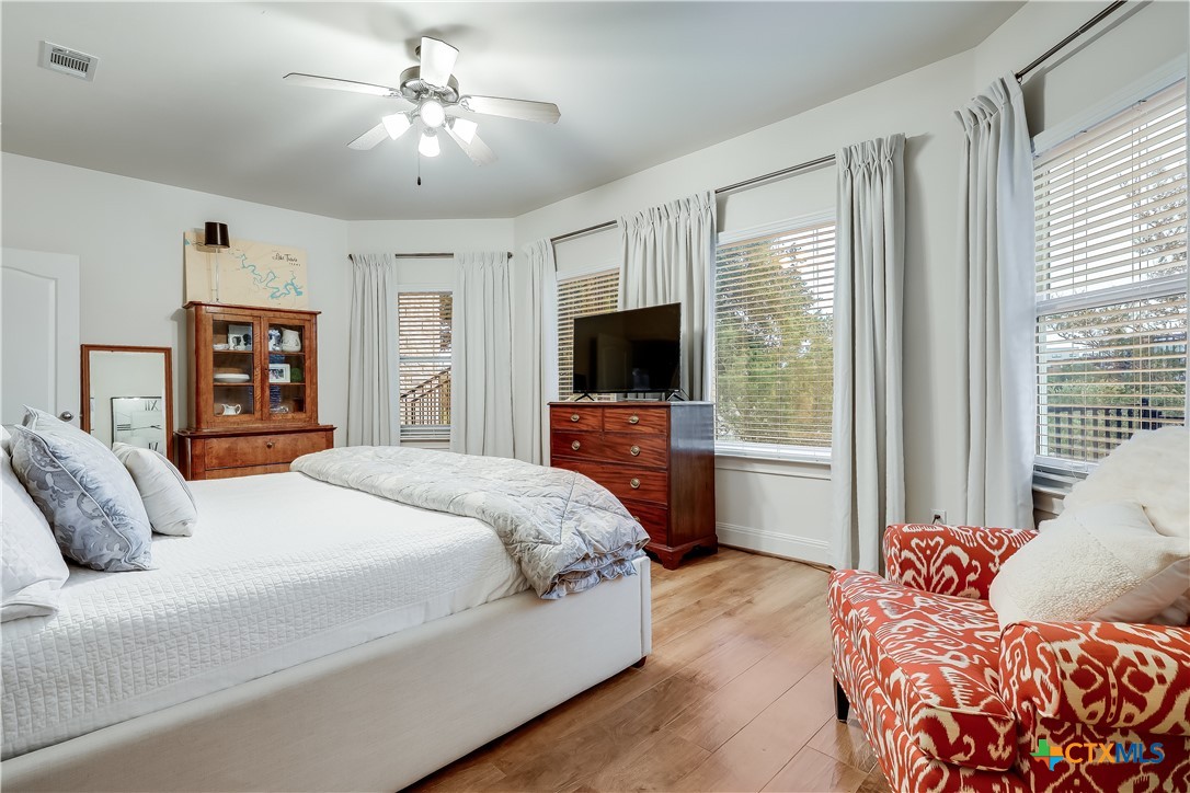 1307 Osprey Ridge Loop Lago Vista, TX 78645 - Photo 30 of 40 a bedroom with a large bed and a flat tv screen