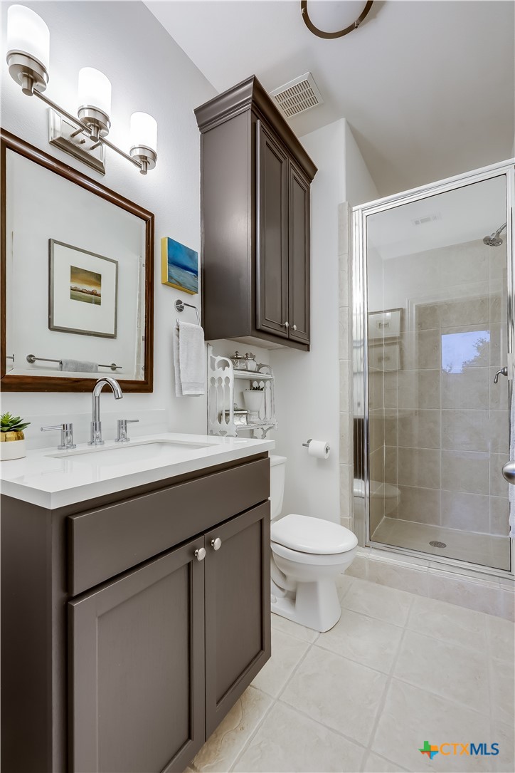 1307 Osprey Ridge Loop Lago Vista, TX 78645 - Photo 31 of 40 a bathroom with a toilet sink and mirror