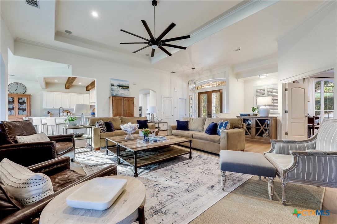 1307 Osprey Ridge Loop Lago Vista, TX 78645 - Photo 6 of 40 a living room with furniture a rug and a chandelier
