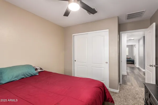 a bedroom with a bed and a chandelier fan