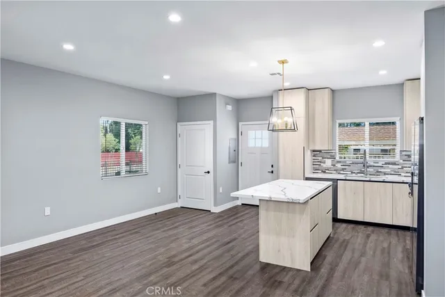 a large kitchen with granite countertop a large counter top and stainless steel appliances