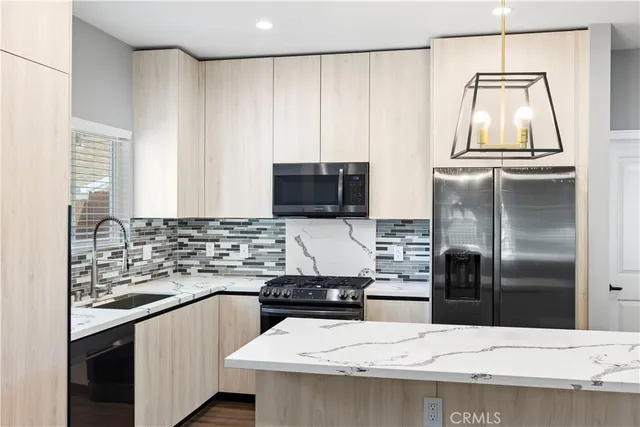 a kitchen with a sink a microwave a refrigerator and cabinets