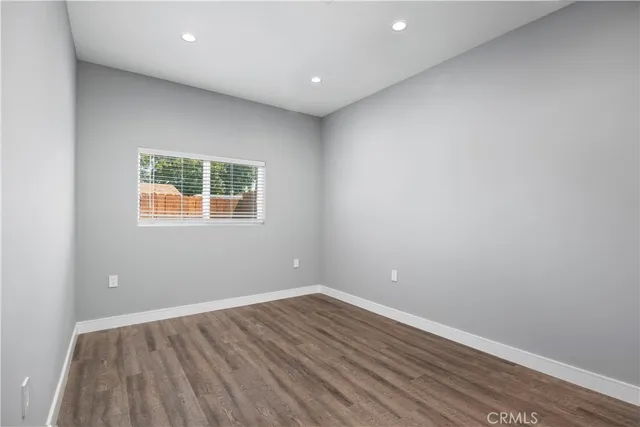 an empty room with wooden floor and a window